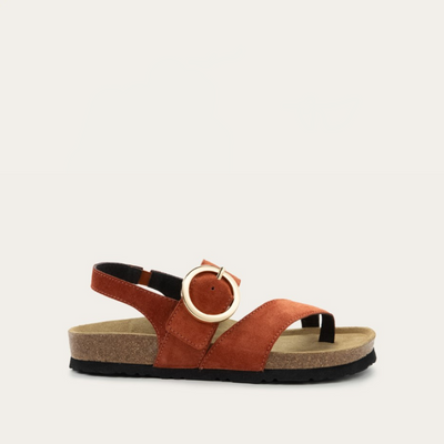A brown strappy sandal with an oversized buckle and a toe thong, featuring a cork sole.