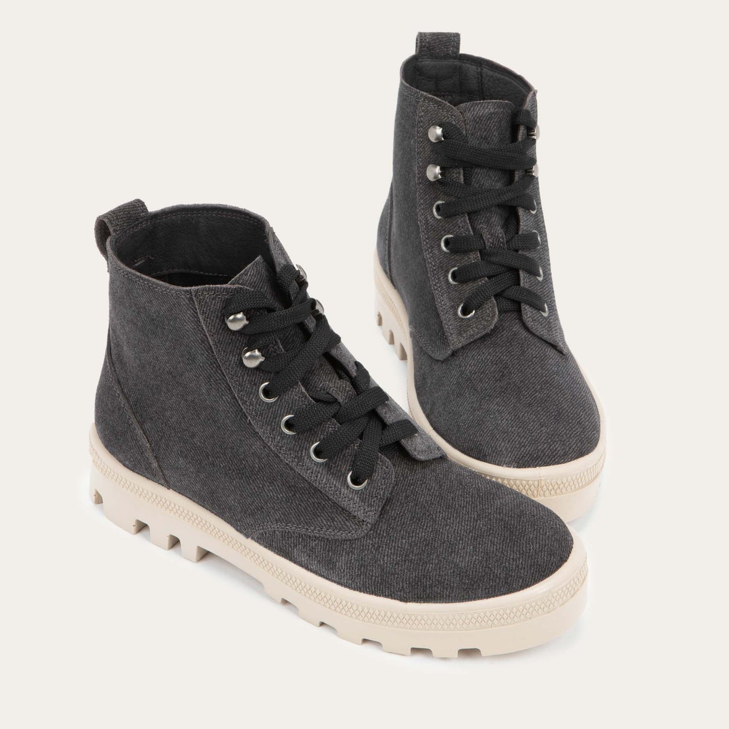 Pair of black textured suede high-top boots with black laces and a light beige sole.