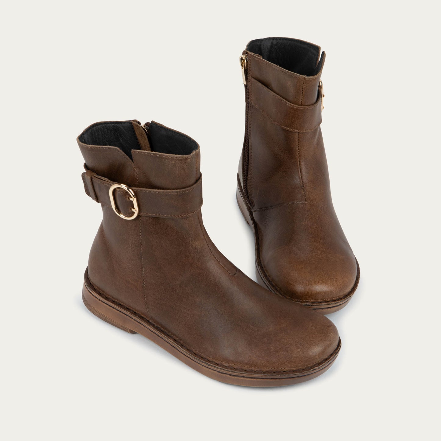 Pair of brown calf boots with a simple strap and buckle detail