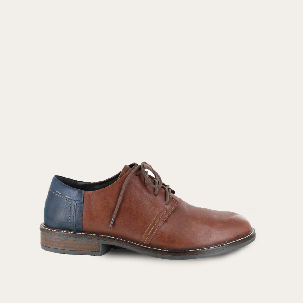 Brown leather shoe with blue insole on a light gray background
