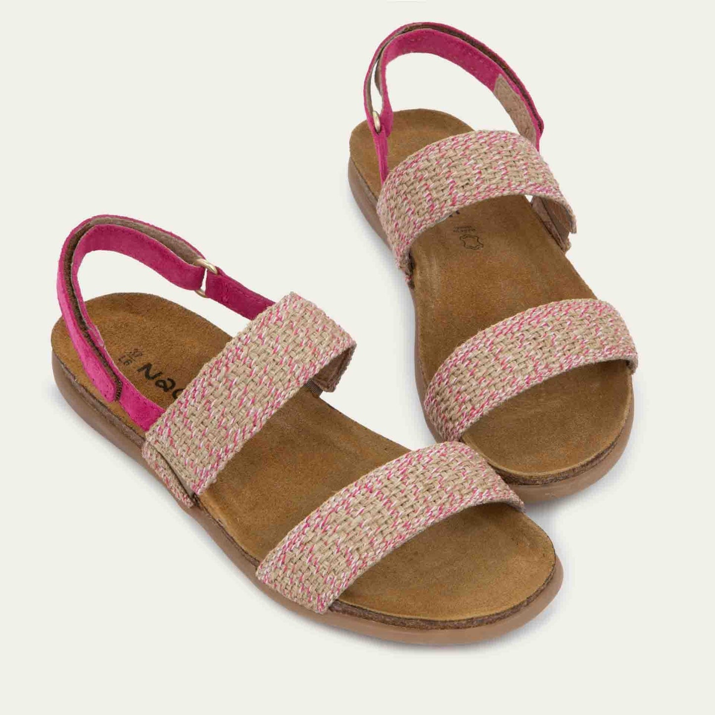 Pair of pink sandals featuring two textured toe straps and an adjustable ankle strap on a cork footbed.