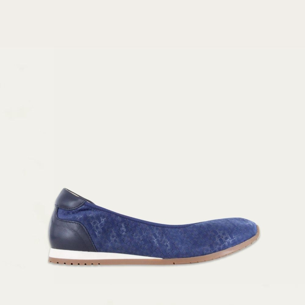 Profile view of a textured blue suede flat on a low white and beige sole.
