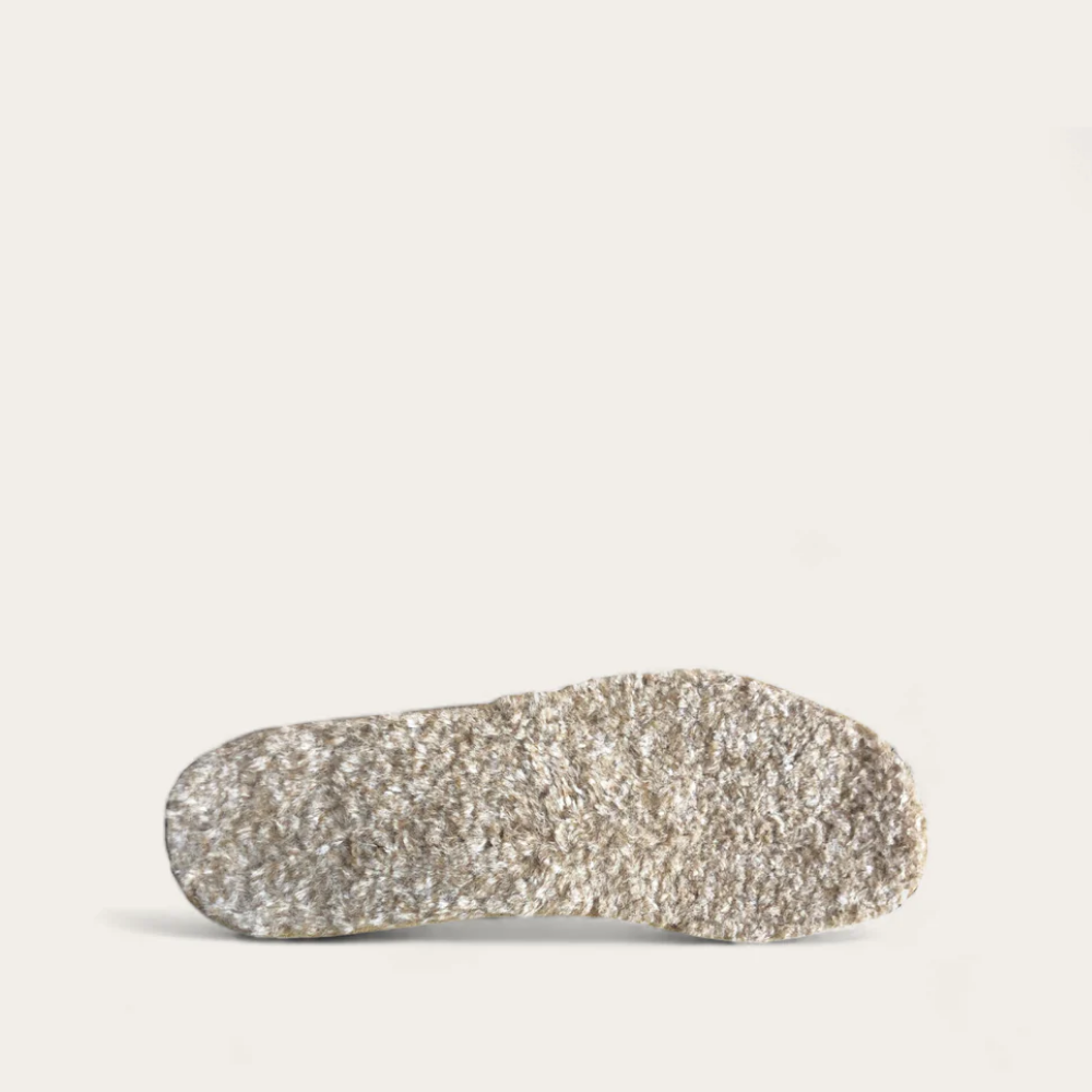 A single beige fur lined footbed designed for women, isolated on a white background.