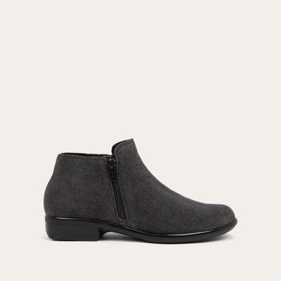 Side view of a black suede bootie on a blacjk and brown sole.
