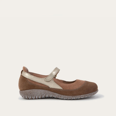 Side view of a brown Mary Jane flat with metallic strap, suede upper, textured sole, and a comfortable, casual design on a plain white background.