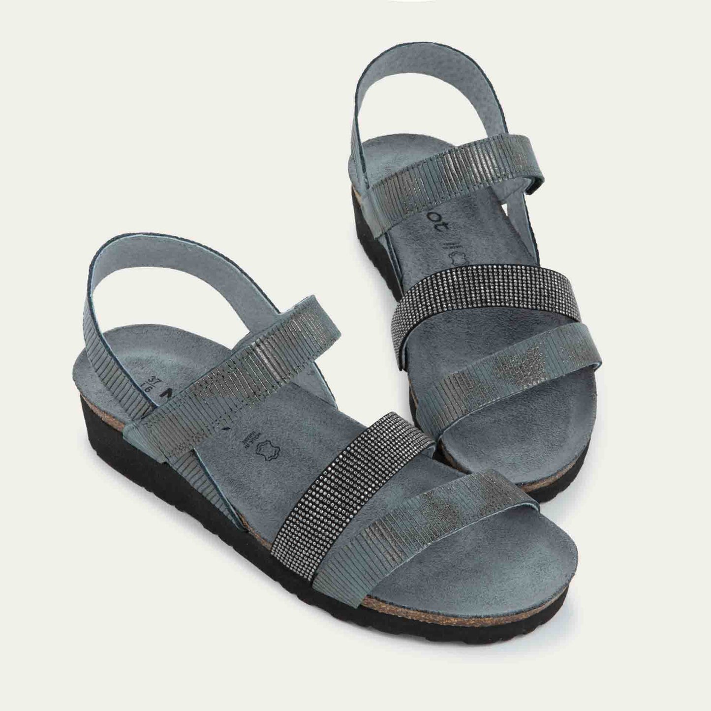 A pair of gray sandals with two textured straps and a studded strap on a cork and black rubber sole,
