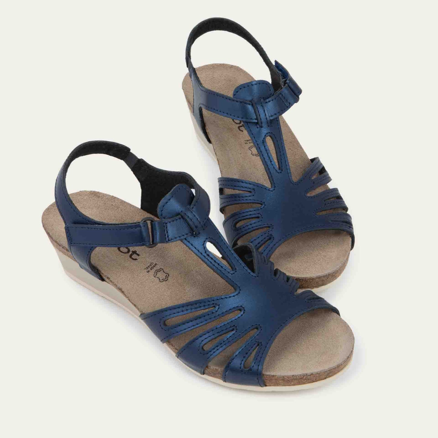 A pair of black wedge sandals with strappy design, open toe, and adjustable ankle strap on a cork footbed.