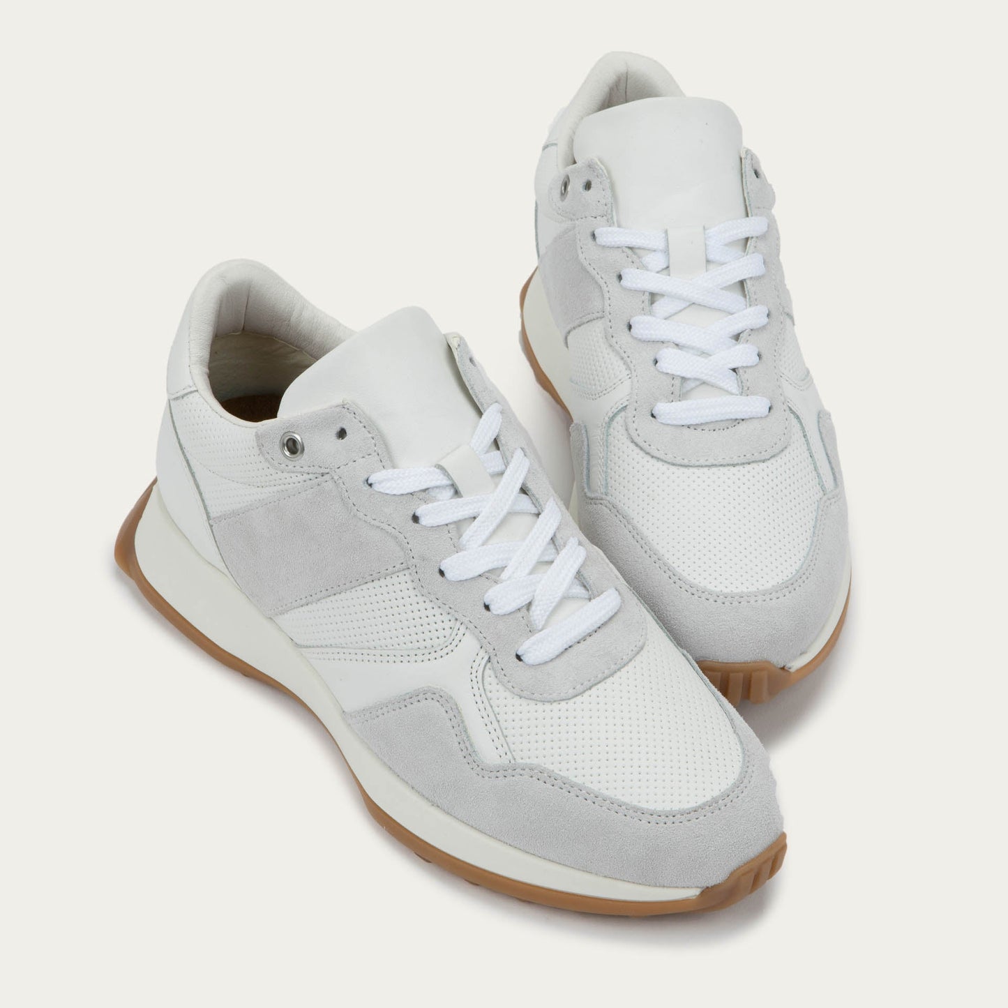 Pair of of a multi-material white lace up sneakers.
