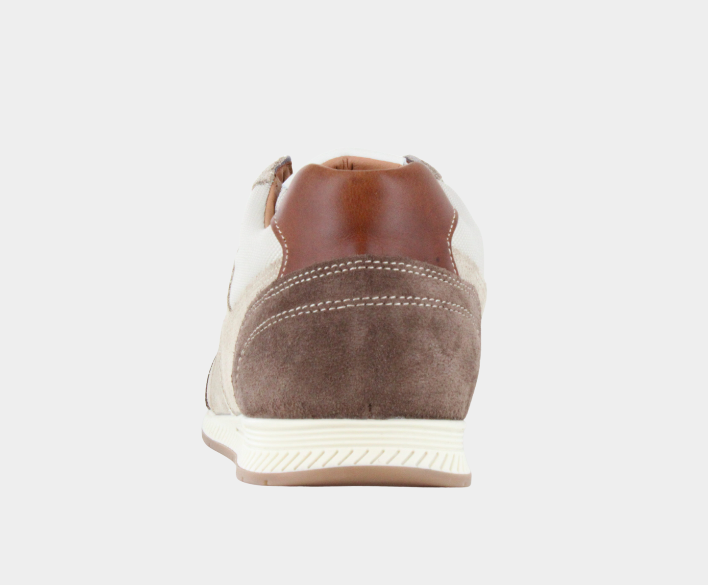 Bottom view of a low-top sneaker featuring beige canvas, light tan suede overlays, a white side stripe, dark brown suede heel, and a white textured rubber sole.