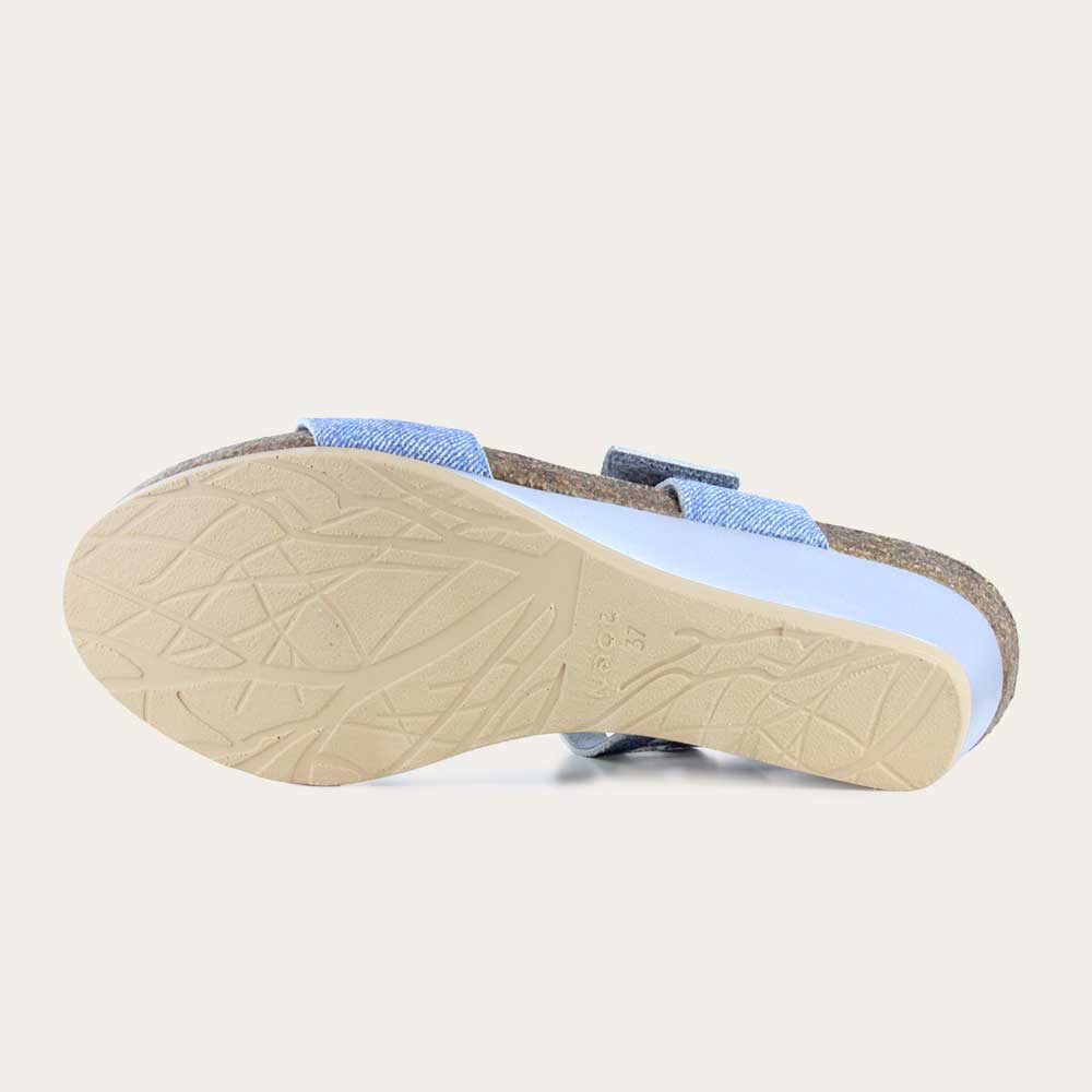 Bottom view of a blue denim wedge sandal, featuring two straps and a metallic buckle with a cork footbed.