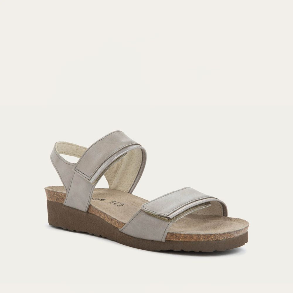 Angled profile view of a silver leather sandal with two adjustable straps and a cork platform sole.