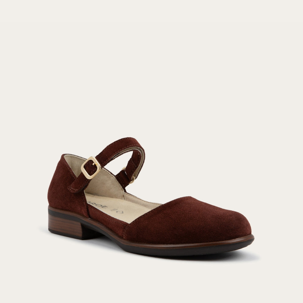 Angled profile view of a red maryjane with a simple buckle strap on a black and brown sole