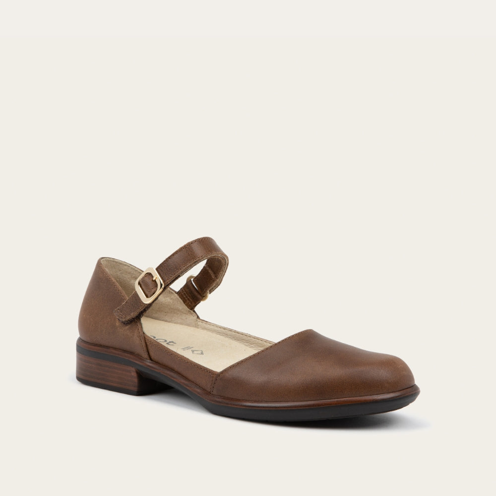 Angled profile view of a brown maryjane with a simple buckle strap on a black and brown sole