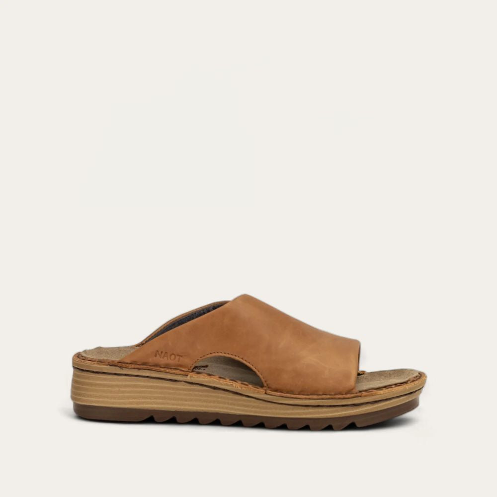 A brown slip-on sandal with a padded upper, cork and latex footbed, and a polyurethane sole.