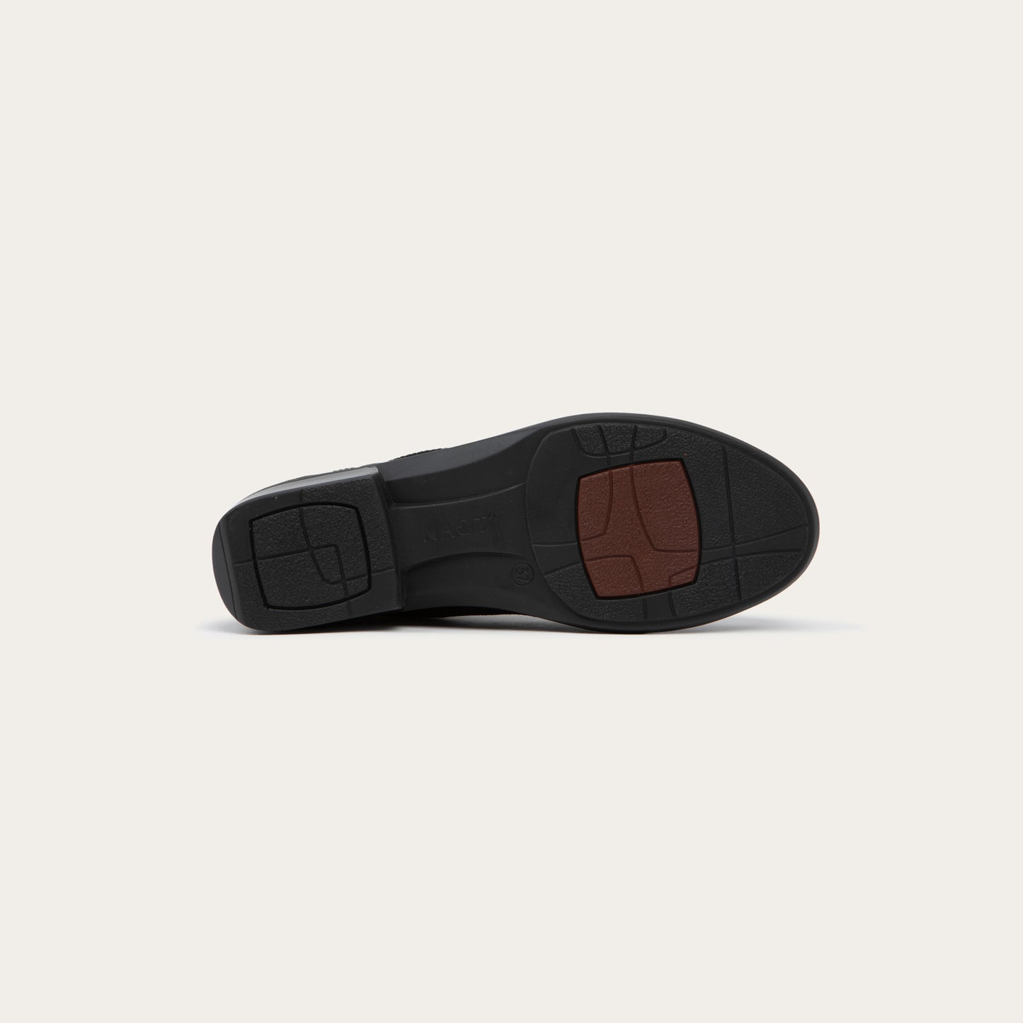 Bottom view of a black ankle boot featuring a textured knit upper, a pull tab at the heel, and a low, flat black sole.