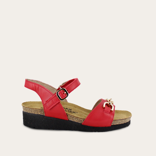 Red sandal with a black sole on a light beige background