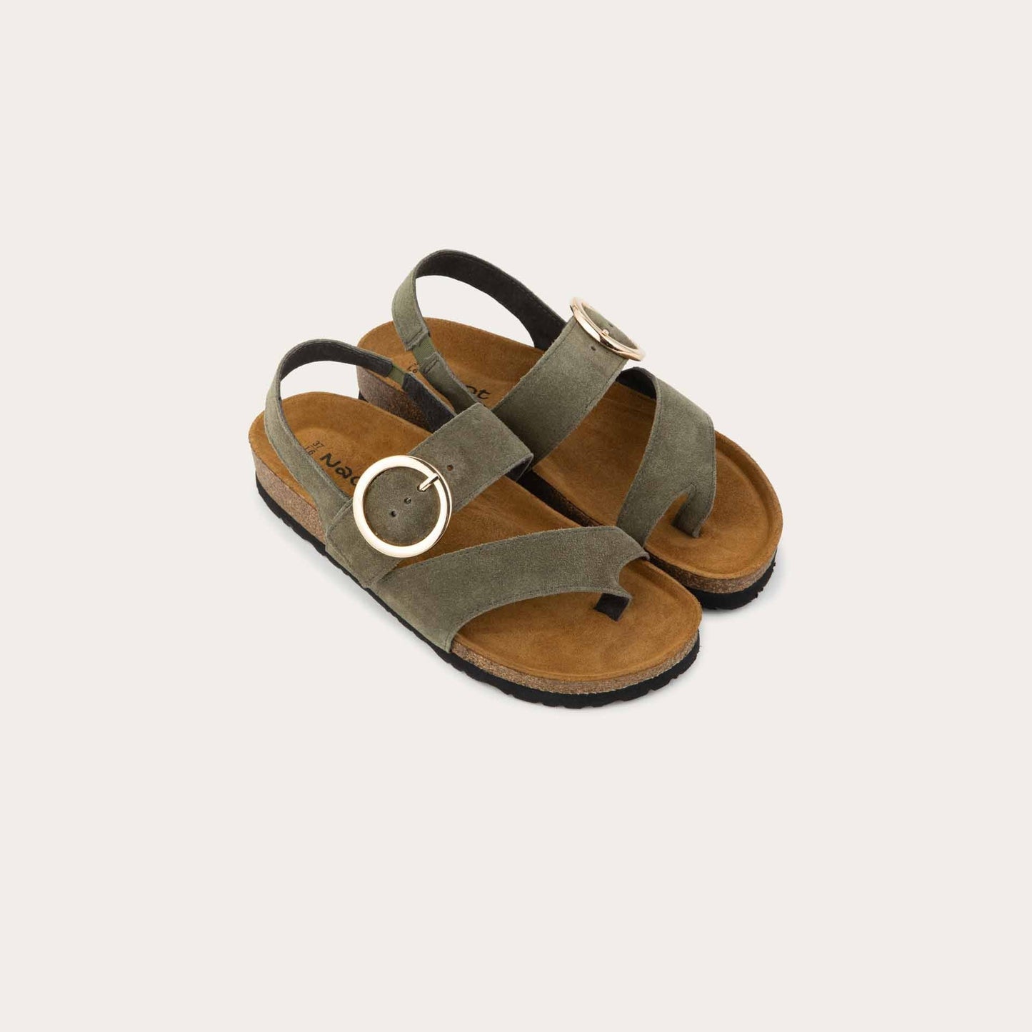 Pair of green strappy slides with an oversized buckle and a toe thong, featuring a cork sole.