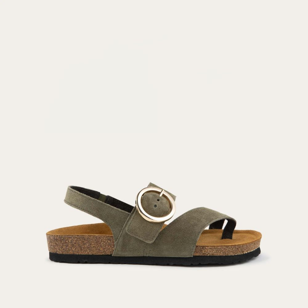 Profile view of a green strappy slide with an oversized buckle and a toe thong, featuring a cork sole.