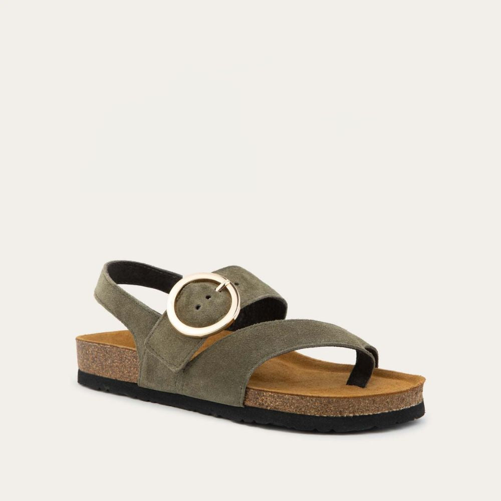 Angled profile view of a green strappy slide with an oversized buckle and a toe thong, featuring a cork sole.
