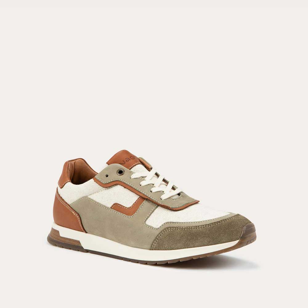 Angled profile view of a green and beige sneaker featuring different materials on a white sole