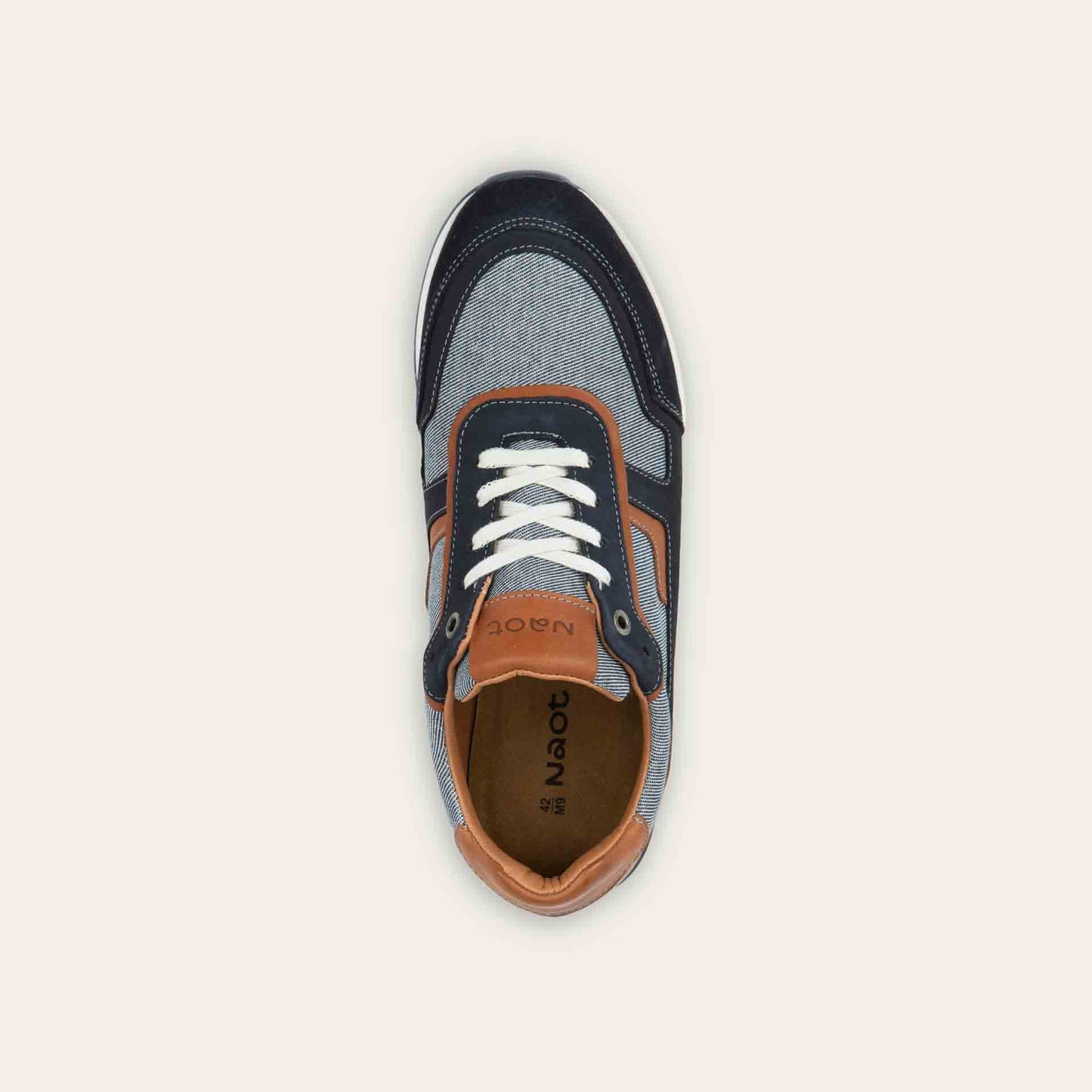Top view of a blue and brown sneaker featuring different materials on a white sole