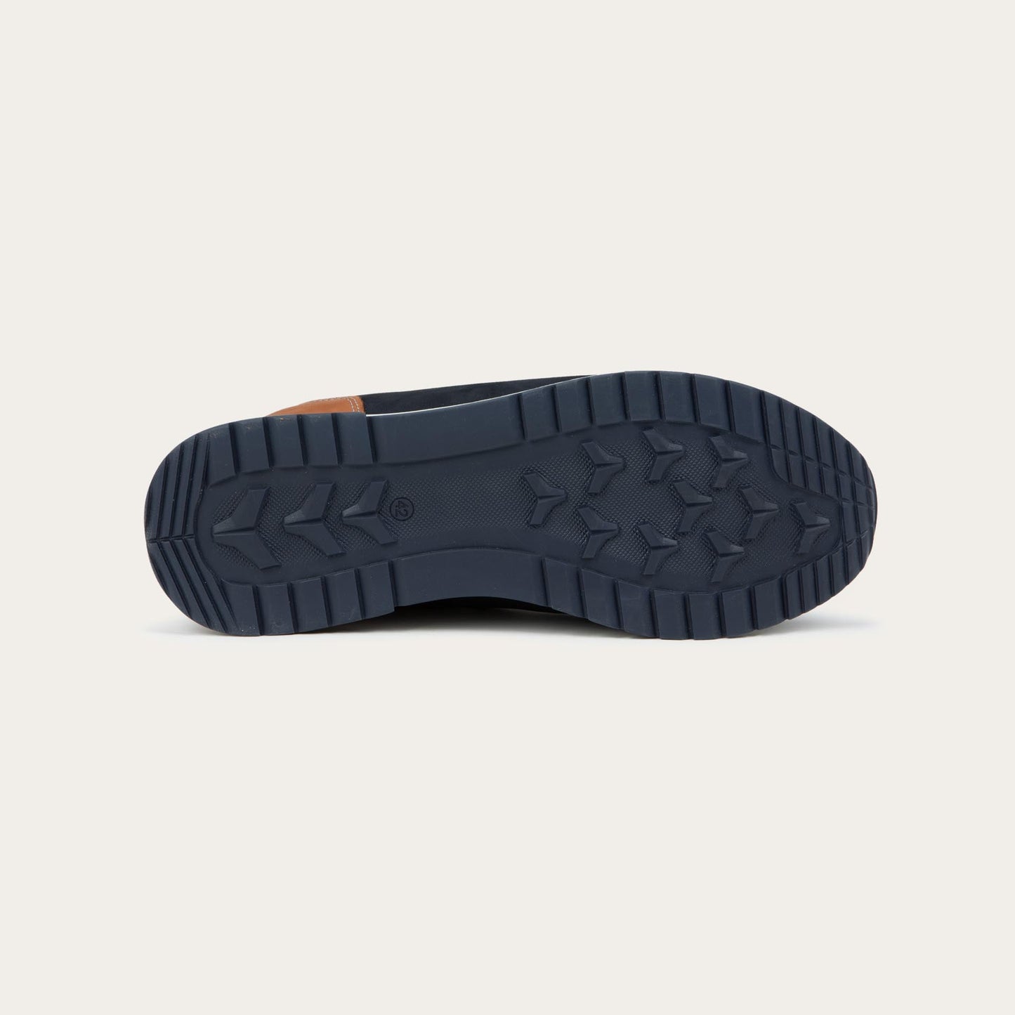 Bottom view of a blue and brown sneaker featuring different materials on a white sole