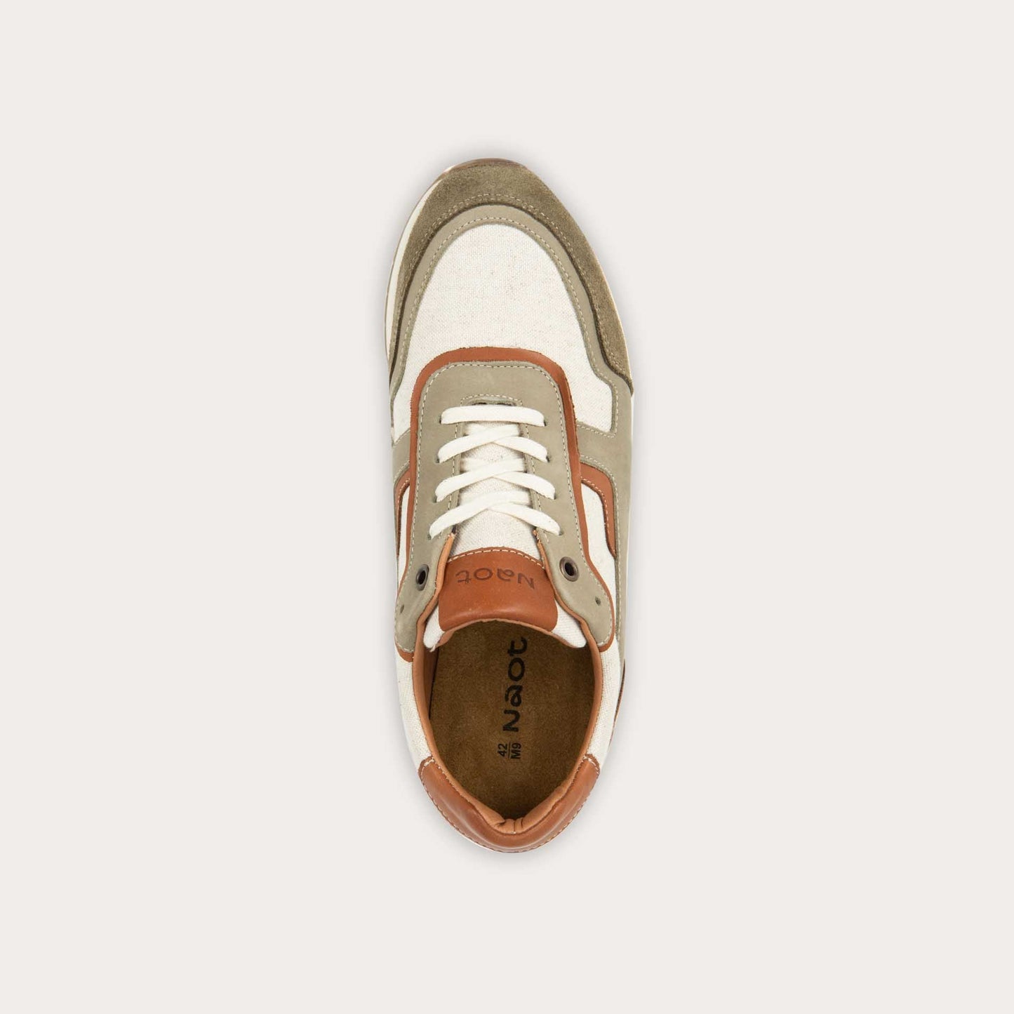 Top view of a green and beige sneaker featuring different materials on a white sole