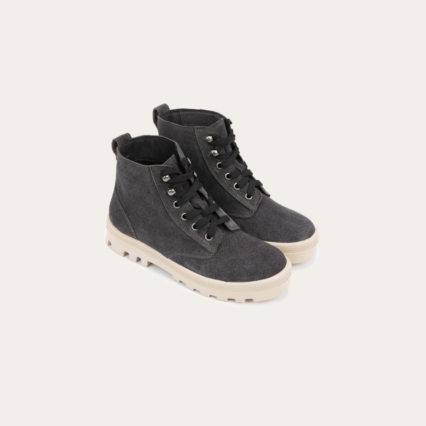 Pair of  black textured suede high-top boots with black laces and a light beige sole. 