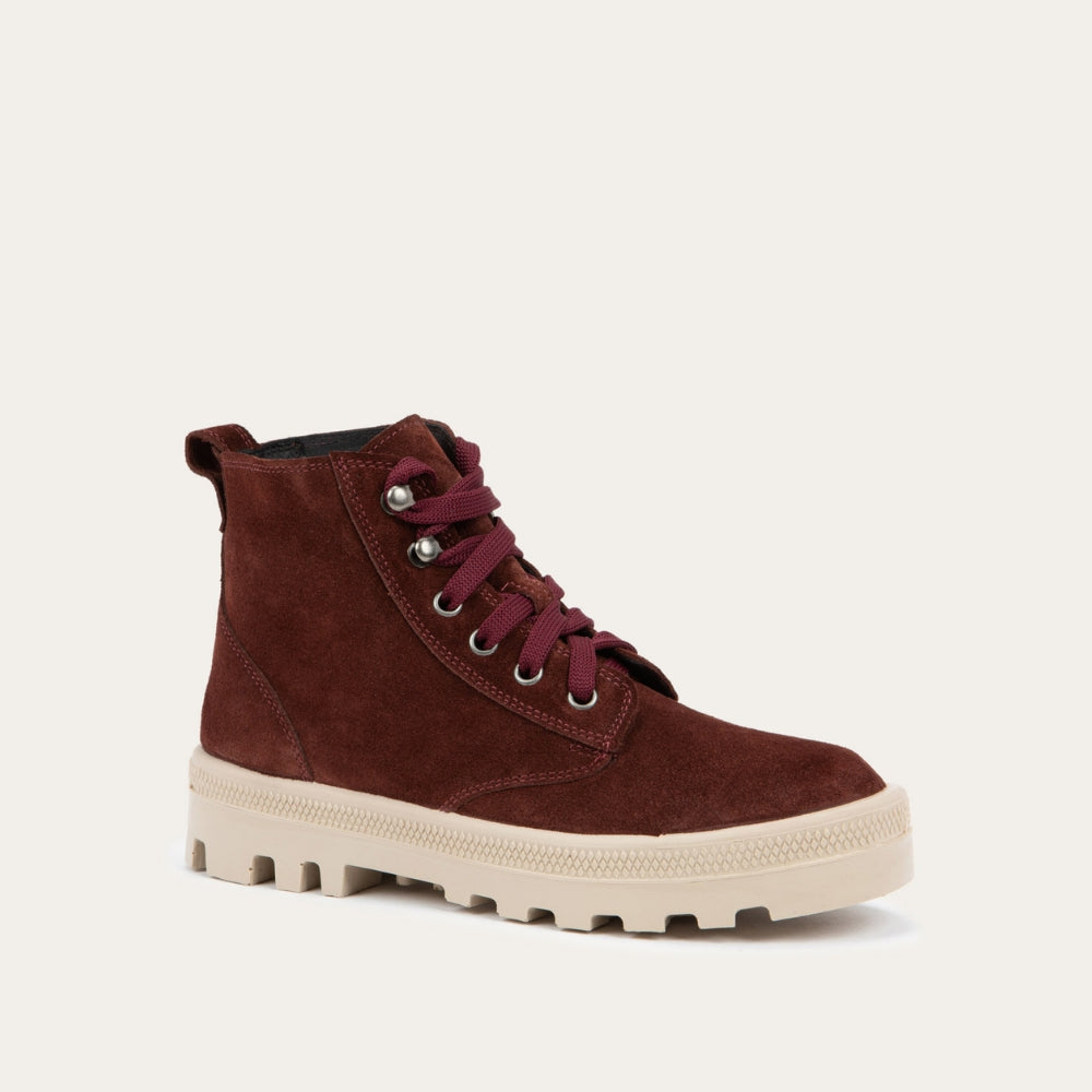Angled profile view of a violet textured suede high-top boot with violet laces and a light beige sole. 