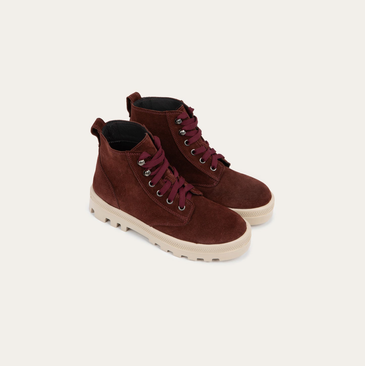 Pair of  violet textured suede high-top boots with violet laces and a light beige sole. 