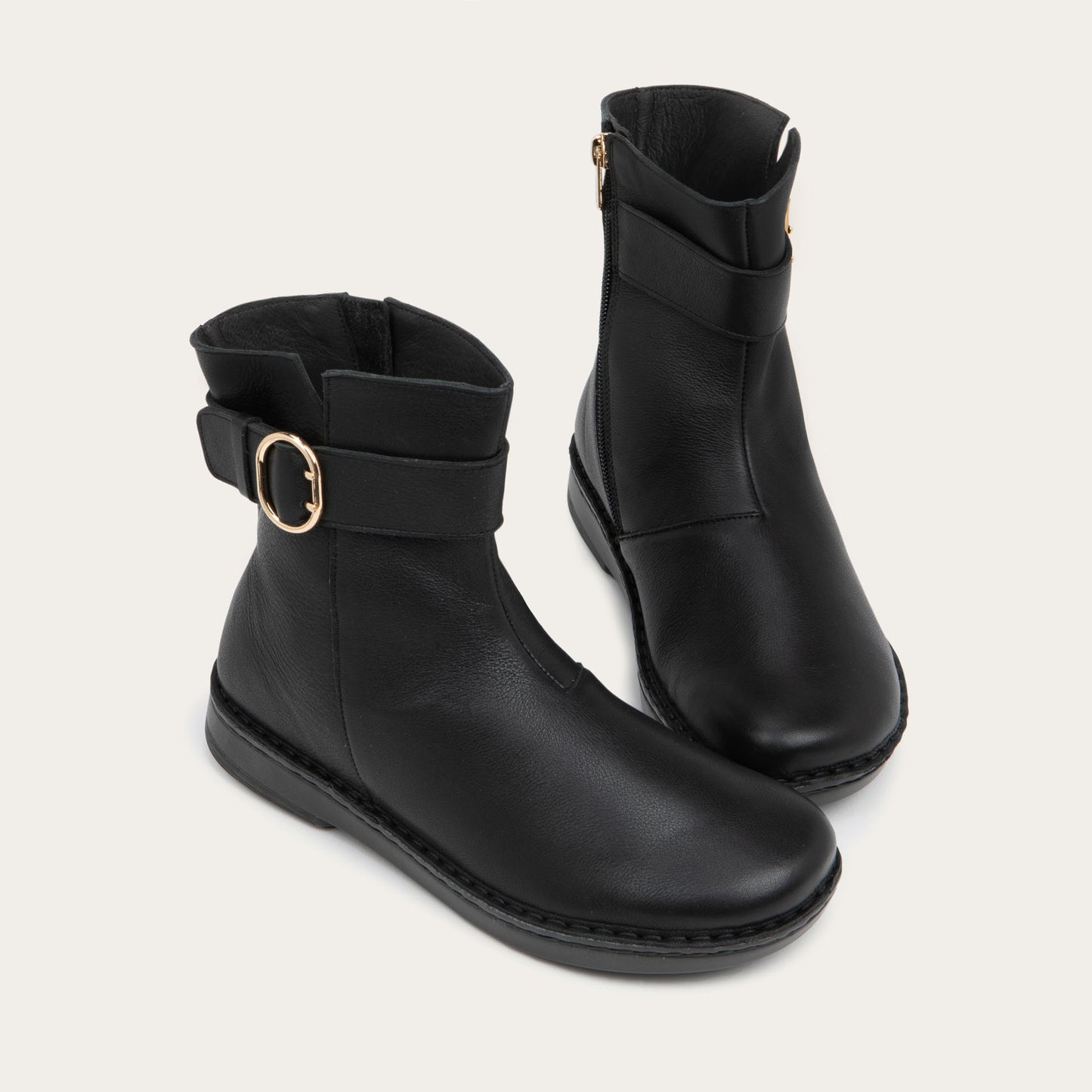 Pair of  black calf boots with a simple strap and buckle detail