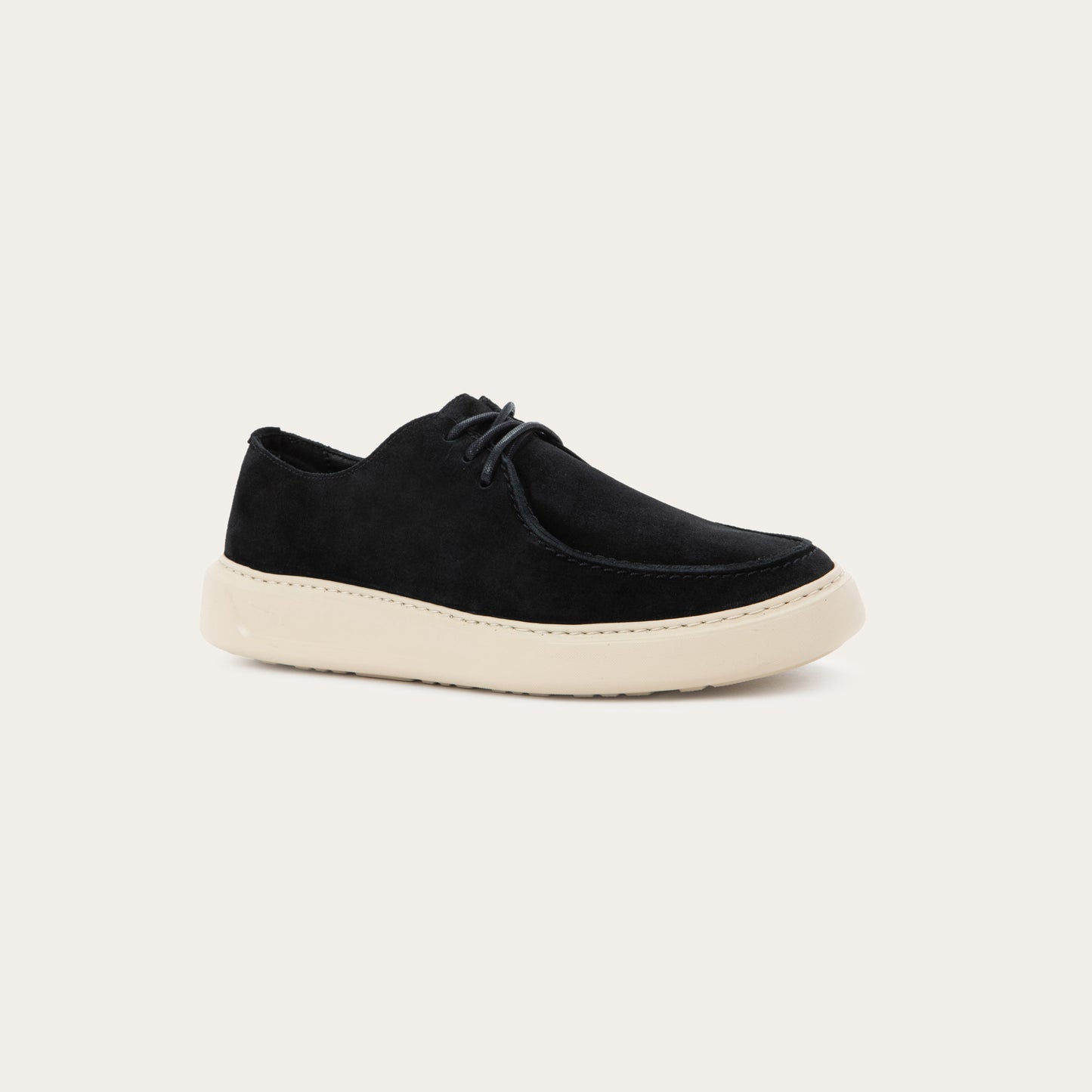 Angled profile view of a black suede lace-up shoe with a moccasin-style toe and a thick, cream-colored rubber sole.