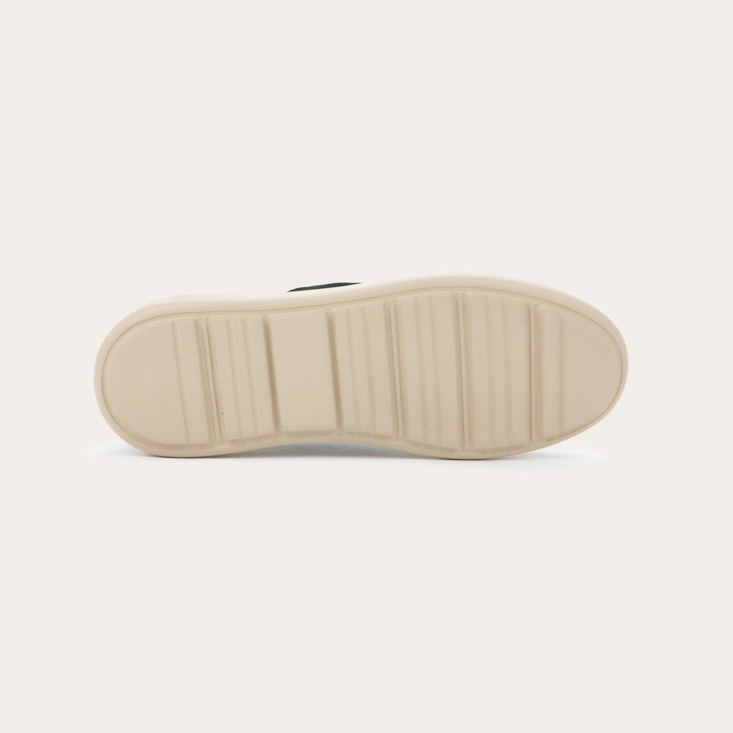 Bottom view of a black suede lace-up shoe with a moccasin-style toe and a thick, cream-colored rubber sole.