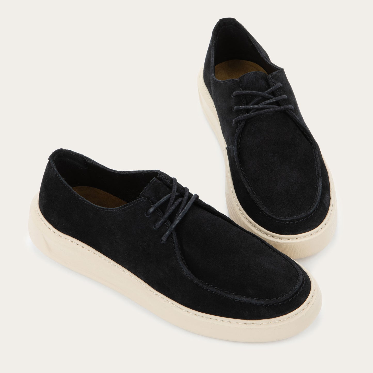 Pair of black suede lace-up shoe with a moccasin-style toe and a thick, cream-colored rubber sole.