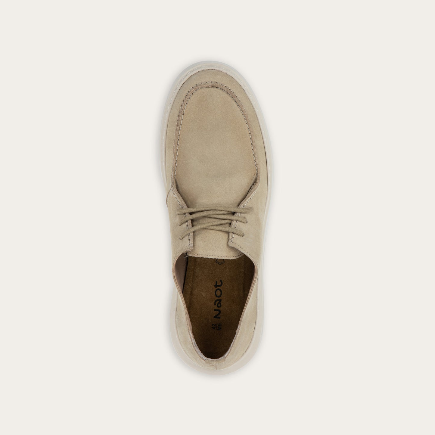 Top view of a beige suede lace-up sneaker with a thick, matching rubber sole and a  stitched toe.