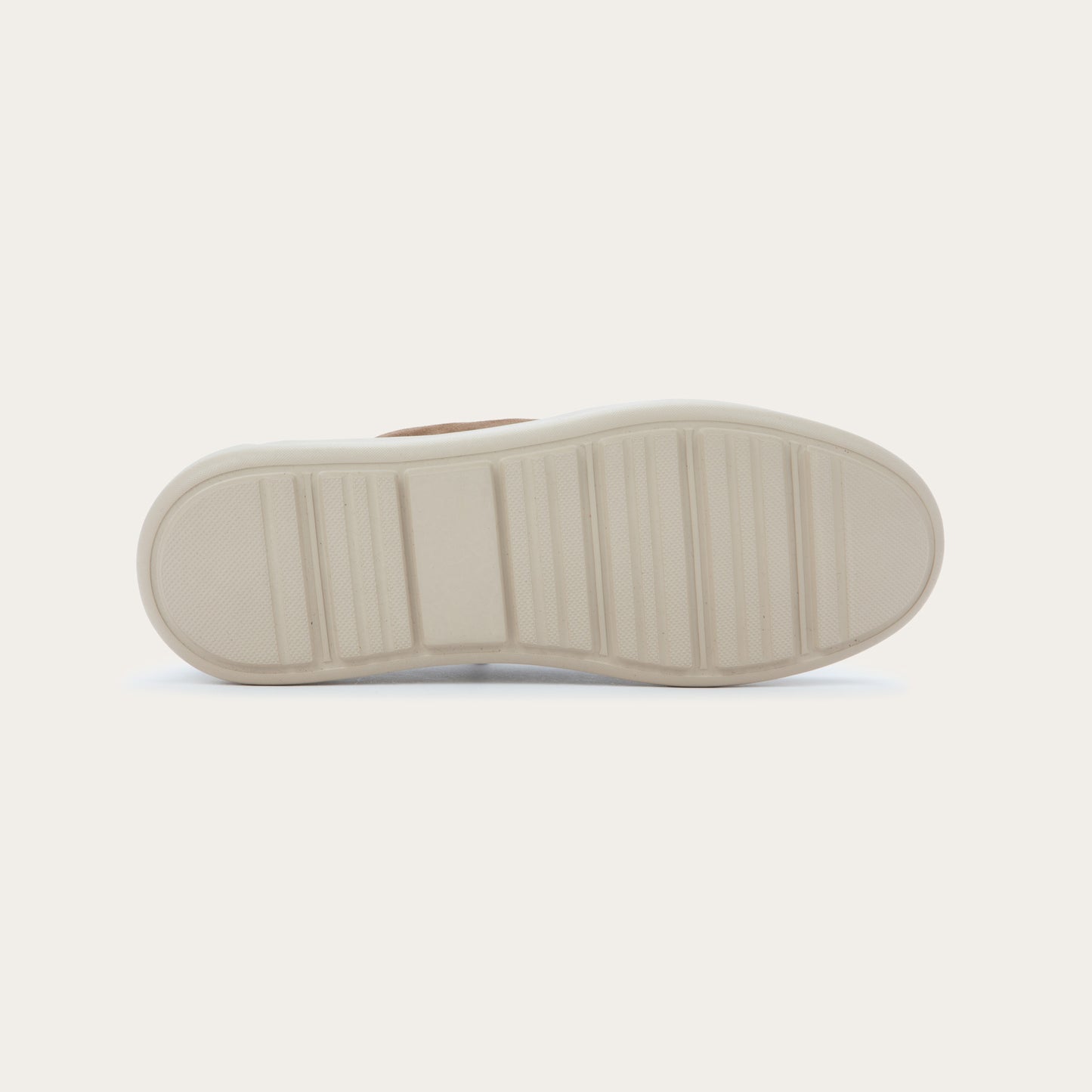 Bottom view of a brown suede lace-up shoe with a thick, off-white rubber sole, featuring a stitched toe and a clean, minimalist design.