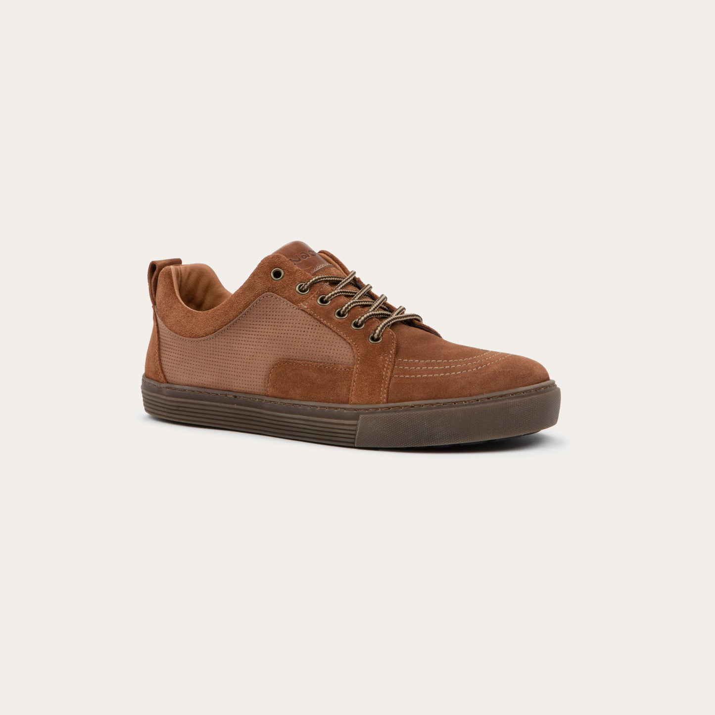 Angled profile view of a  brown suede and perforated leather sneaker with matching brown laces and a textured rubber sole.