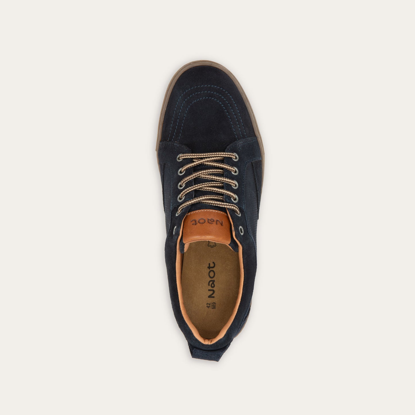 Top view of a black low-top sneaker with tan laces, a brown sole, and tan interior lining, 
