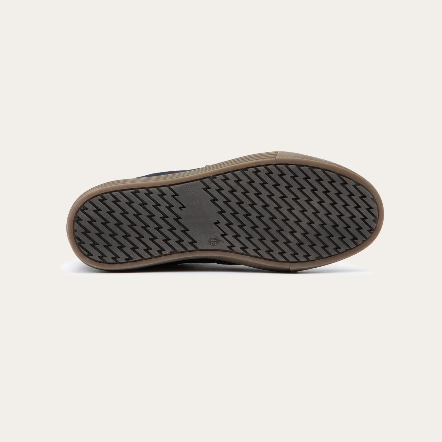 Bottom view of ablack low-top sneaker with tan laces, a brown sole, and tan interior lining, 