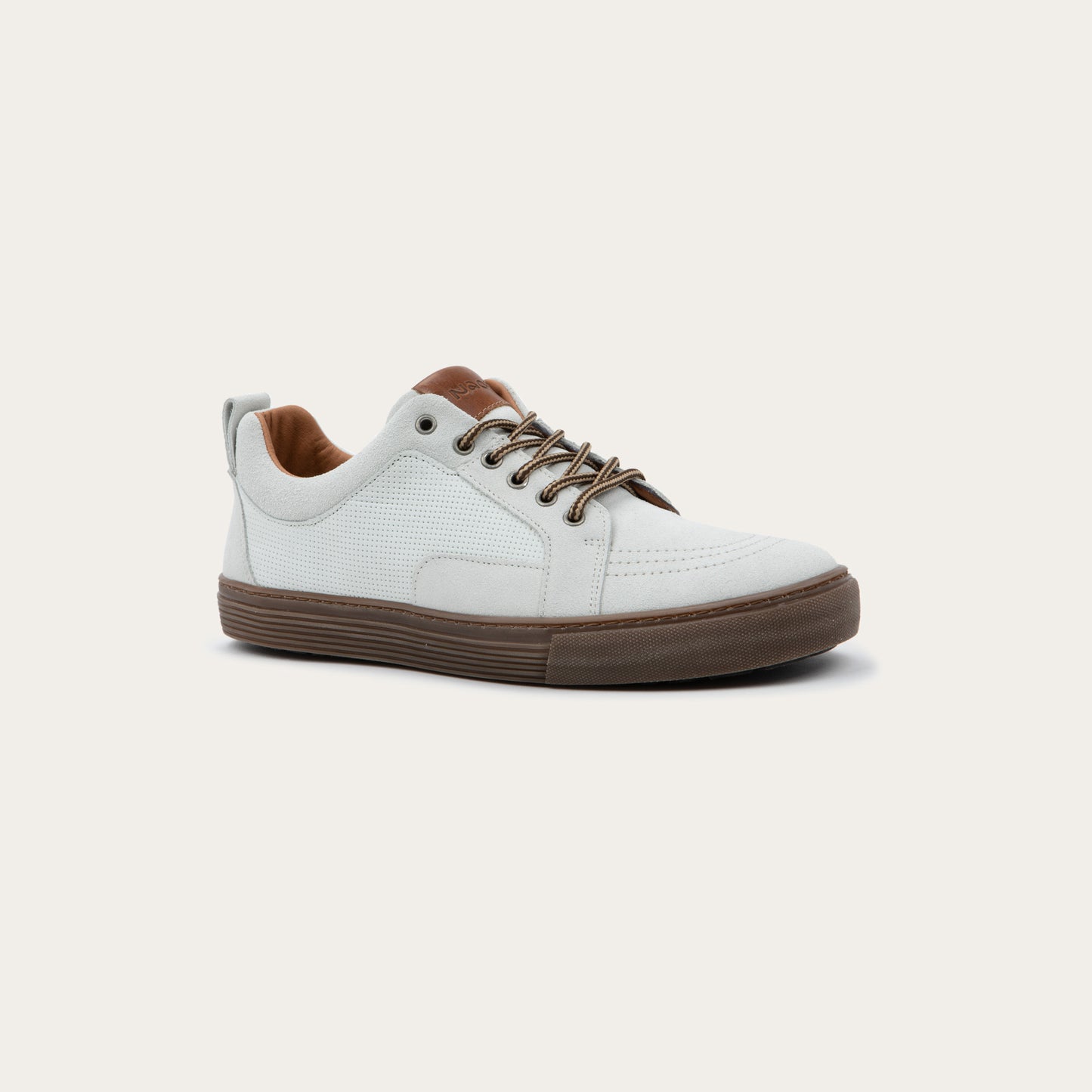 Angled profile view of a gwhite low-top sneaker with brown laces, brown inner lining, and a brown rubber sole.