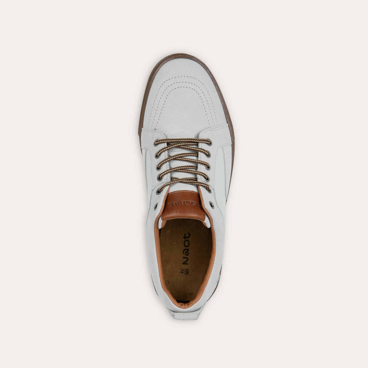 Top view of a white low-top sneaker with brown laces, brown inner lining, and a brown rubber sole.
