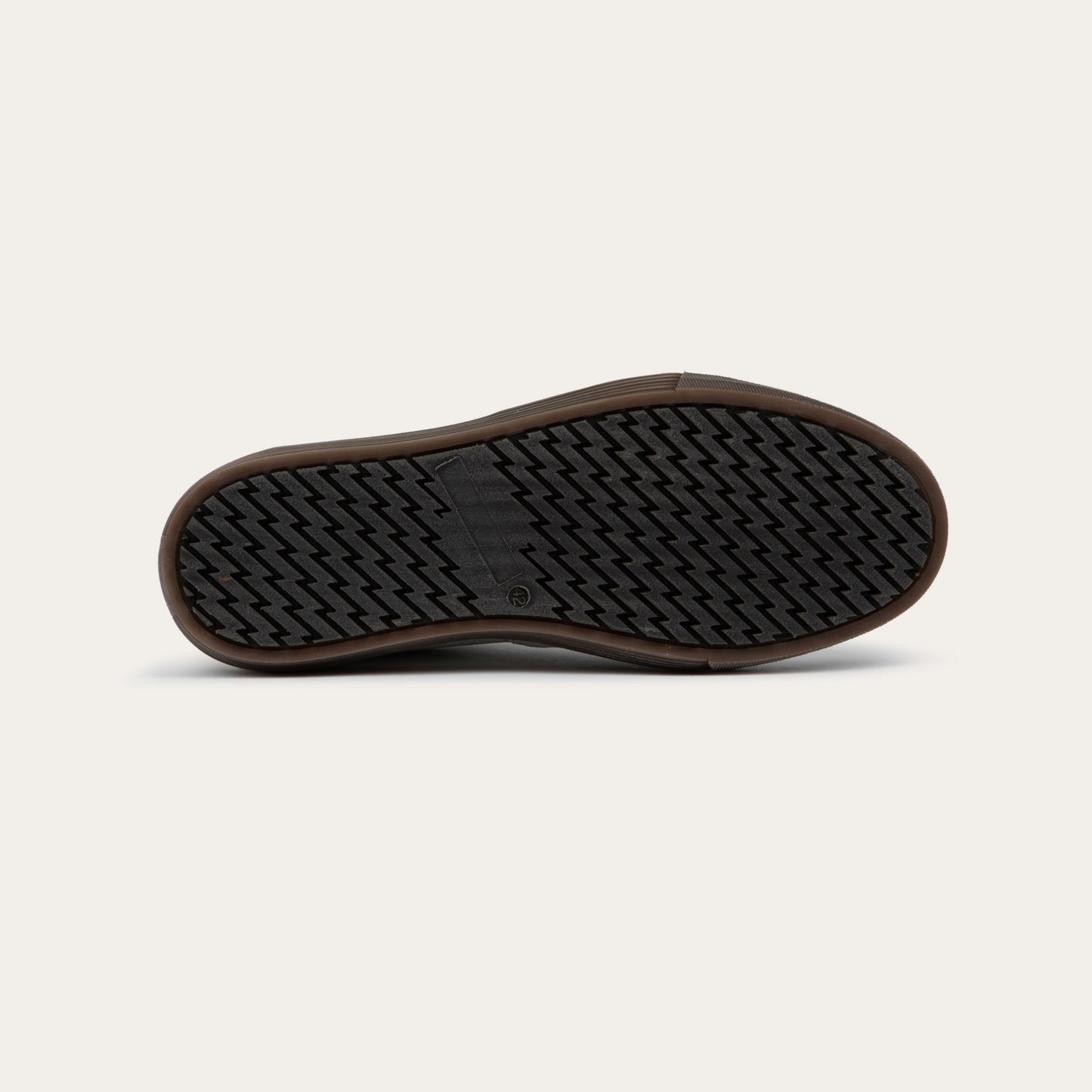Bottom view of awhite low-top sneaker with brown laces, brown inner lining, and a brown rubber sole.