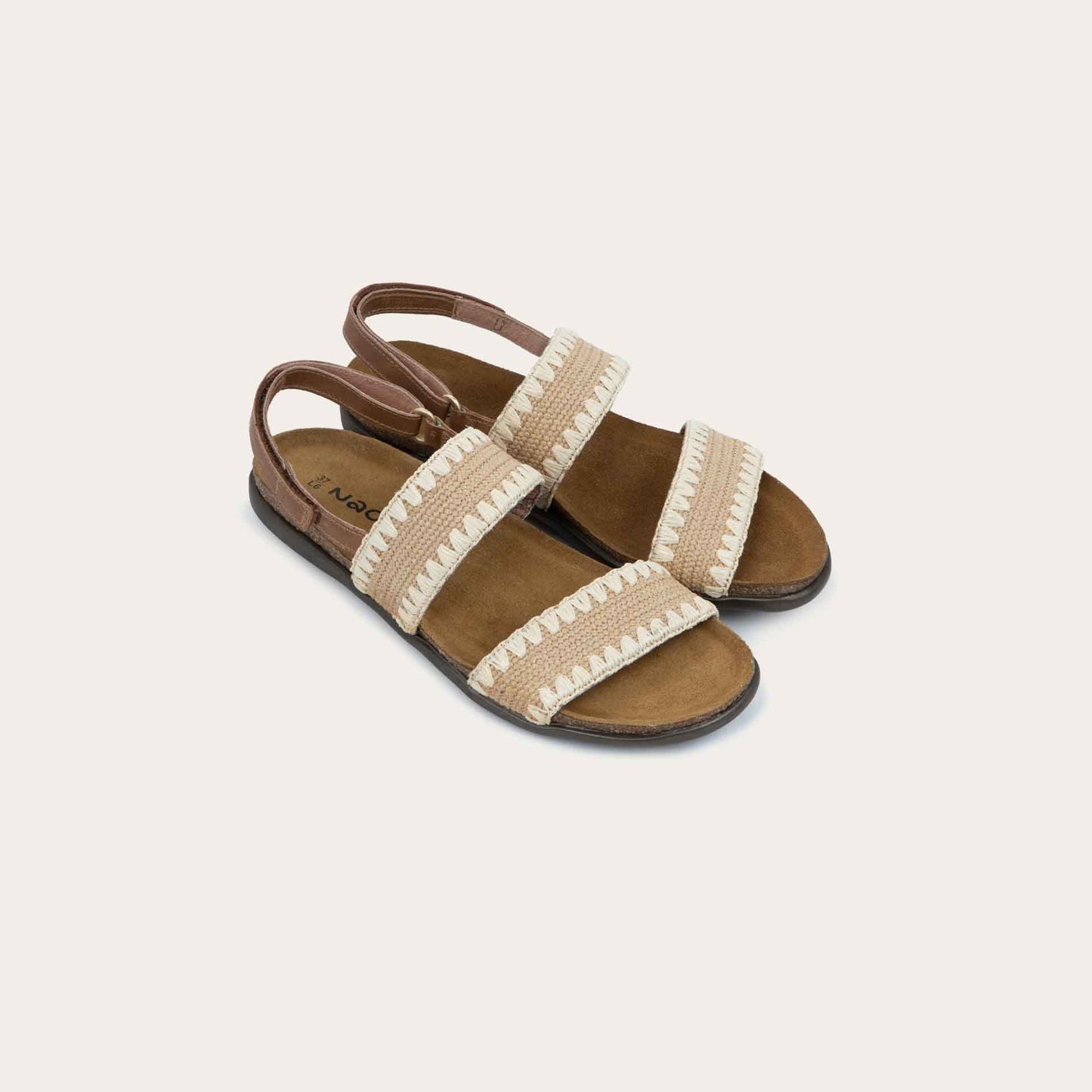 Pair of  brown sandals featuring two textured toe straps and an adjustable ankle strap on a cork footbed.