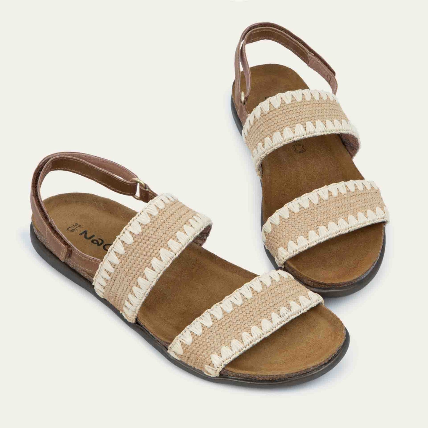 Pair of  brown sandals featuring two textured toe straps and an adjustable ankle strap on a cork footbed.