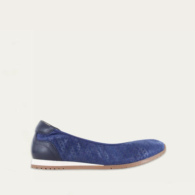 Profile view of a textured blue suede flat on a low white and beige sole. 