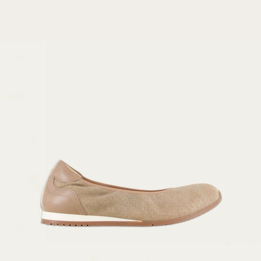 Profile view of a textured beige suede flat on a low white and beige sole. 