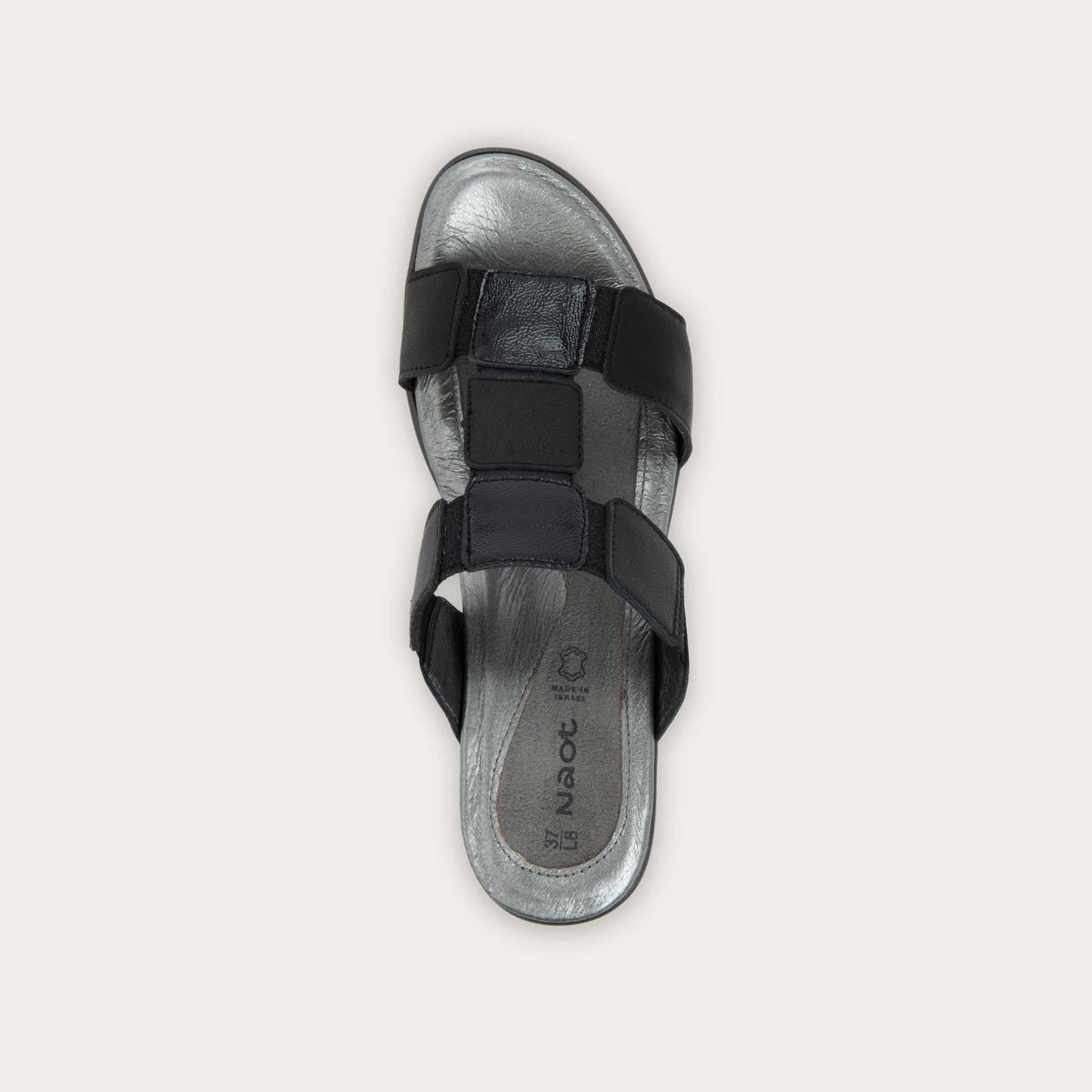 Top view of a slip-on t-strap black sandal with a mid-height heel .