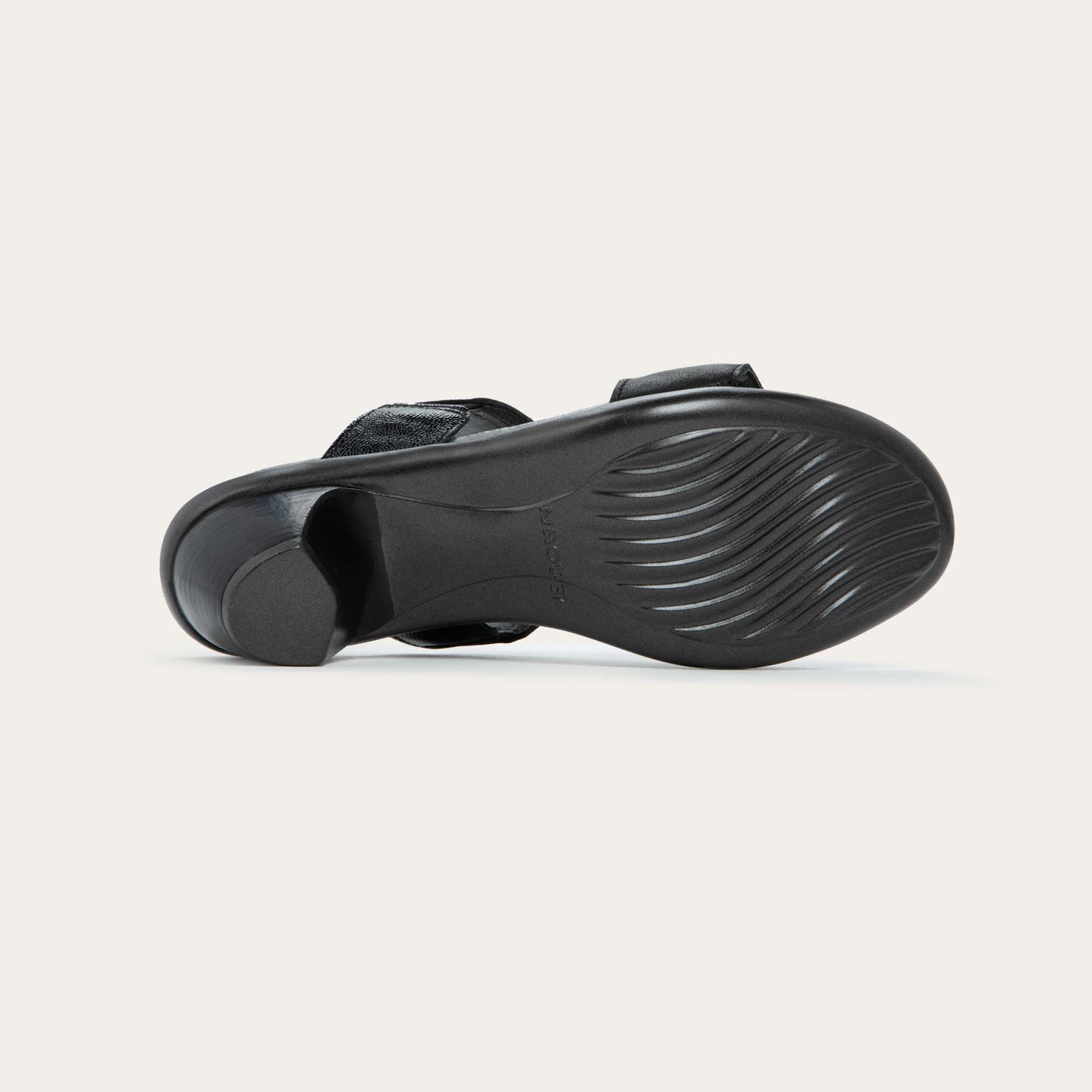 Bottom view of a slip-on t-strap black sandal with a mid-height heel .