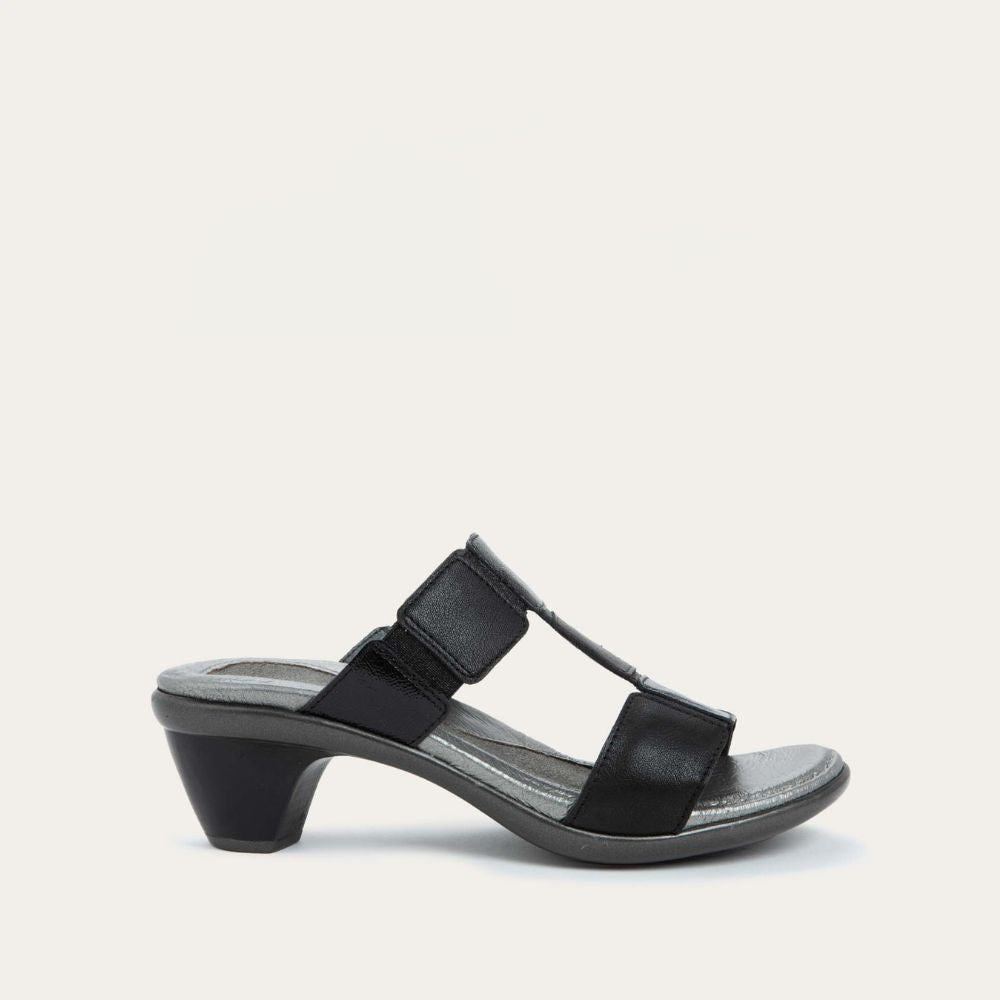 Profile view of a slip-on t-strap black sandal with a mid-height heel .