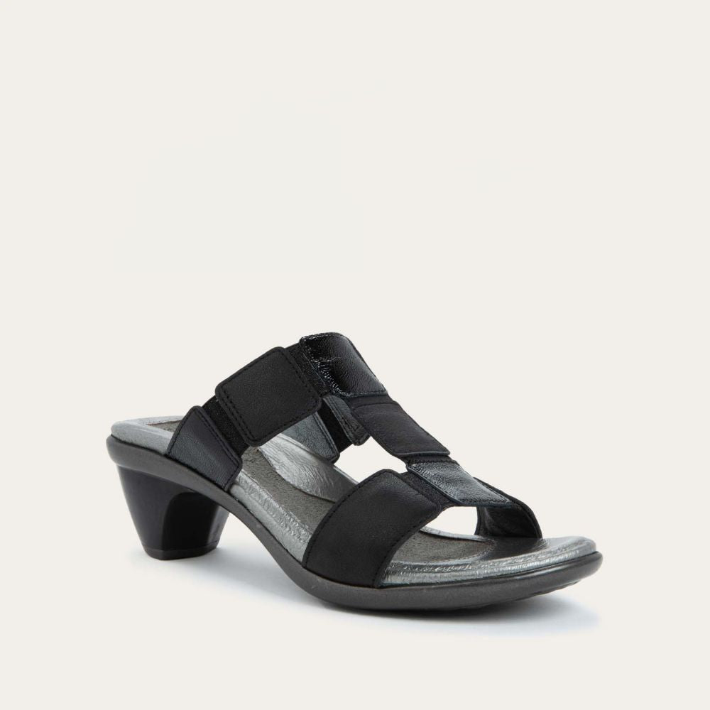 Angled profile view of a slip-on t-strap black sandal with a mid-height heel .
